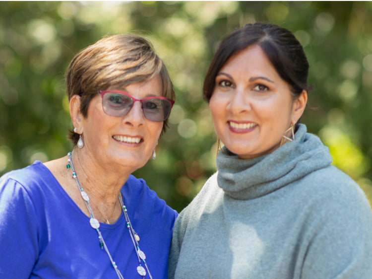 A mom wearing an eyeglass and a daughter smiling