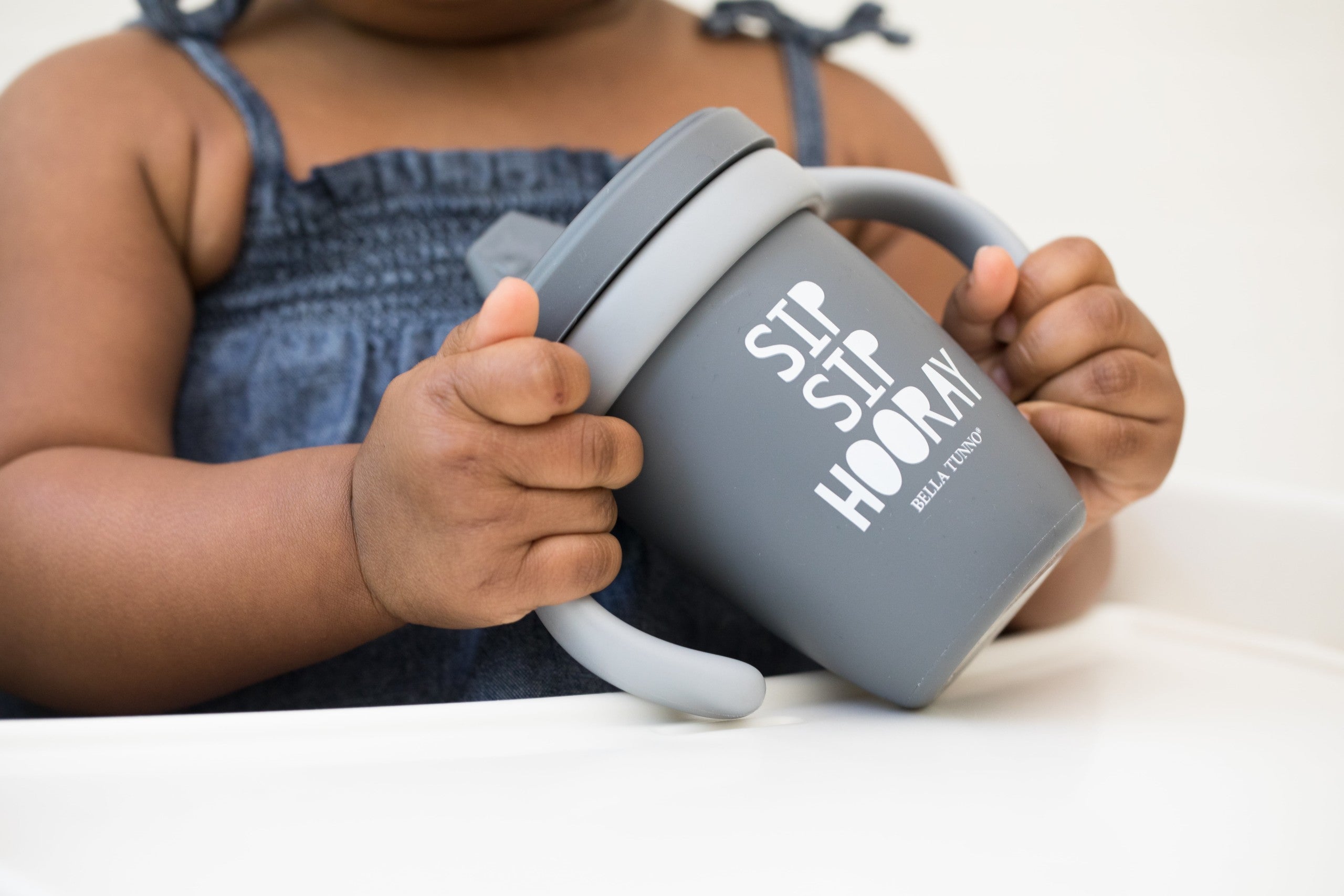 Sip Sip Hooray Happy Sippy Cup by Bella Tunno being held by a girl kid