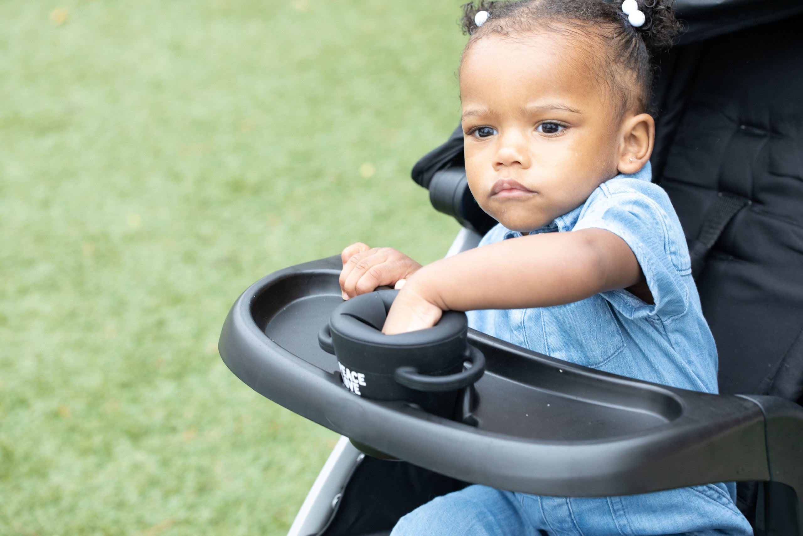 Peace Love Snack Happy Snacker by Bella Tunno being used by a kid in a stroller