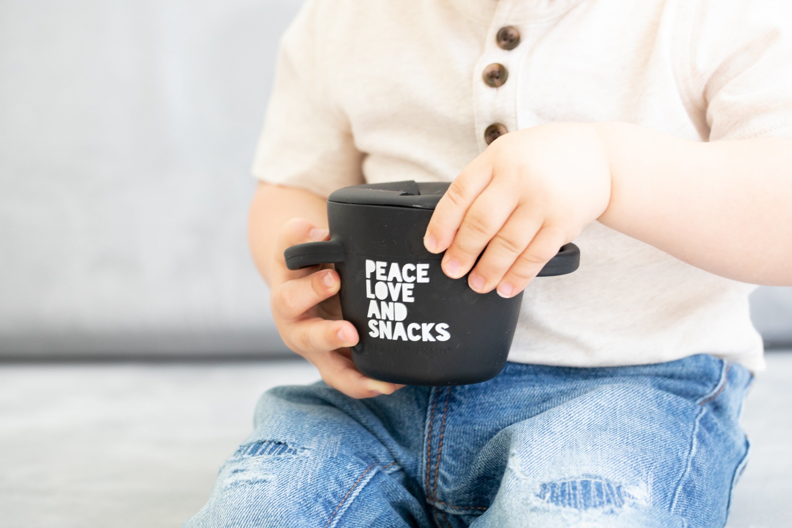 Peace Love Snack Happy Snacker by Bella Tunno's being held by a kid