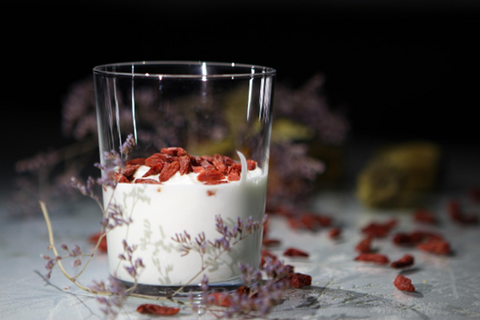Yogurt in a clear glass topped with dried fruit